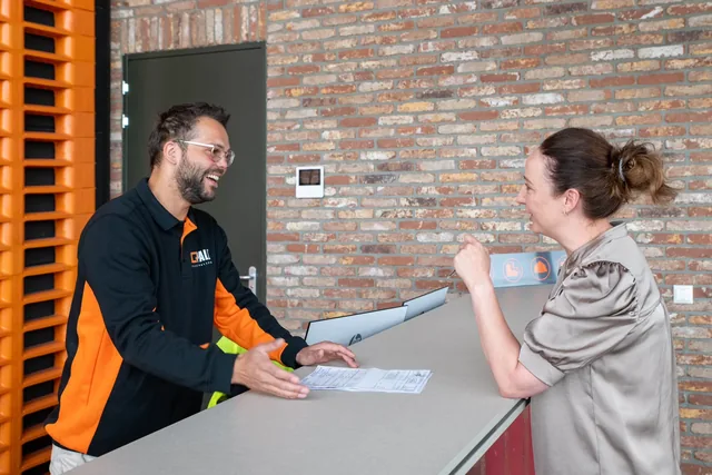 Collega's van Q-Pall in gesprek aan de balie van het kantoor in Veghel