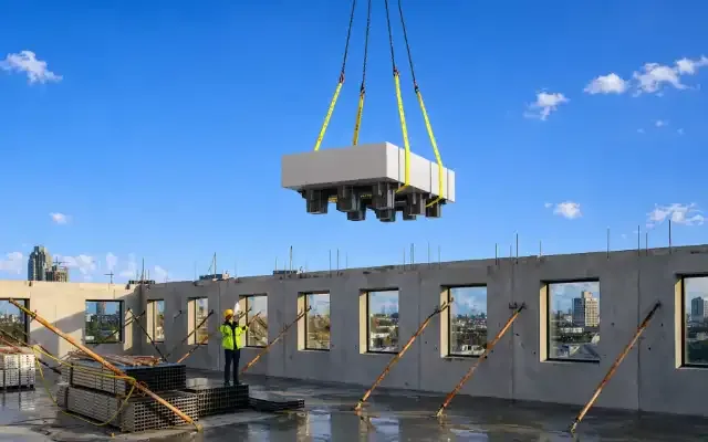 Stack-Up Pallet met gipsplaten wordt met een kraan op een bouwplaats gehesen